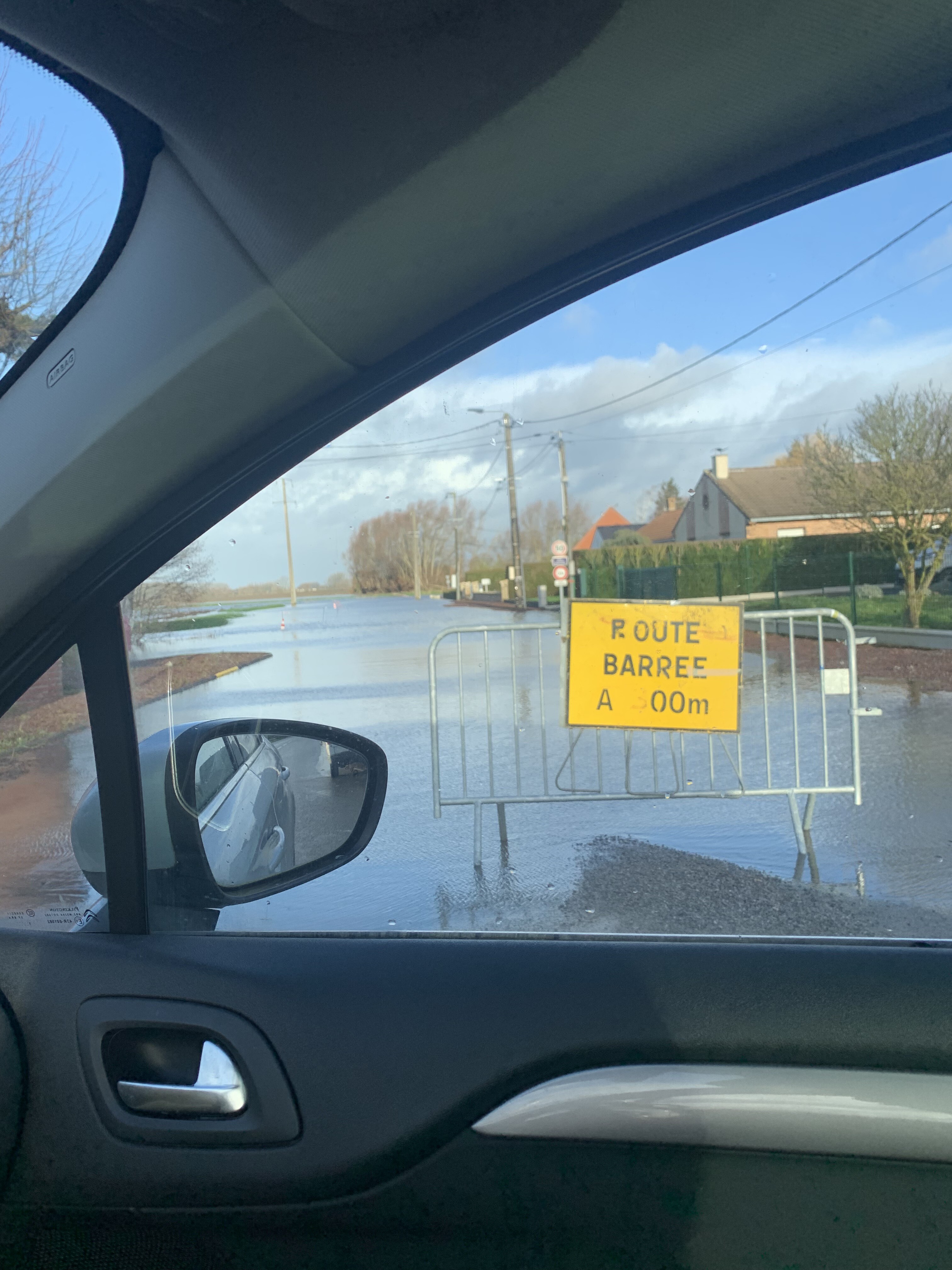 rétroviseur de voiture derrière une vitre humide. vue de la route